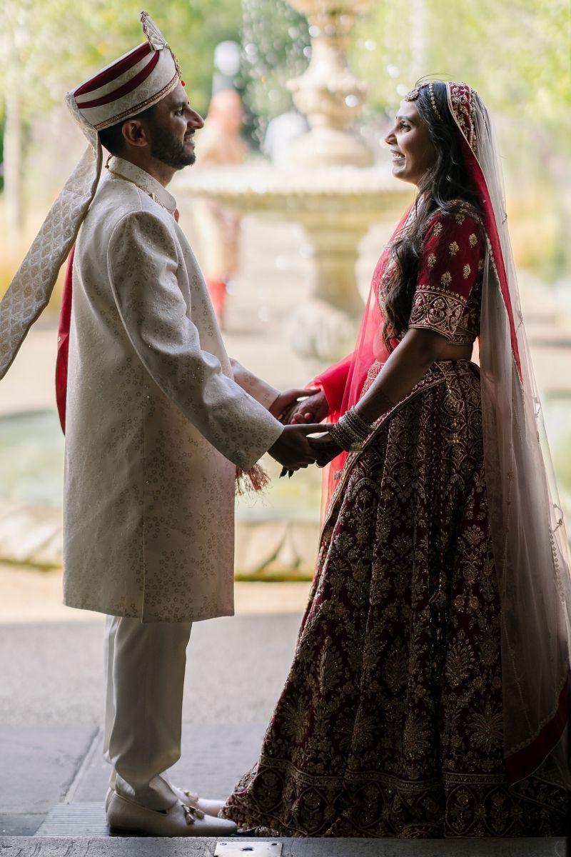 Asian Bride & Groom pose beside a water fountain at Froyle Park