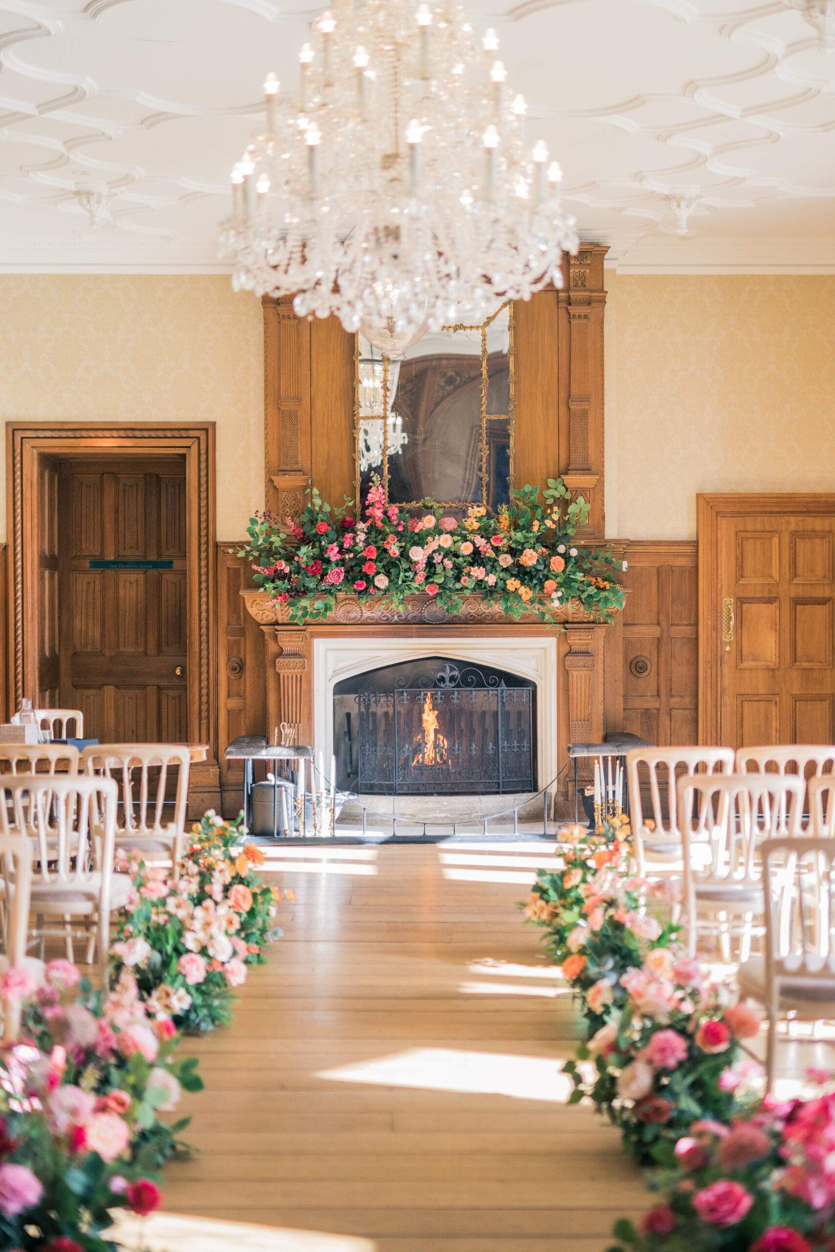 A civil ceremony setup in Froyle Park's Great Hall, featuring shimmering chandeliers and a real fire place, perfect for Winter Weddings.