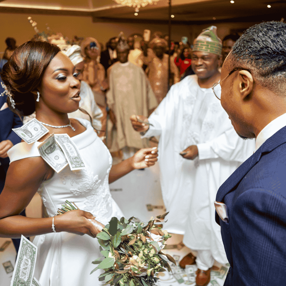 A stunning African-Caribbean bride enjoys a money dance at Froyle Park at her wedding reception in the Grand Ballroom