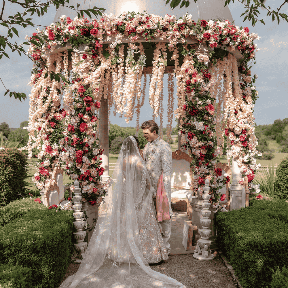 a couple seal their Hindu wedding ceremony with a kiss beneath the adorned outdoor mandap
