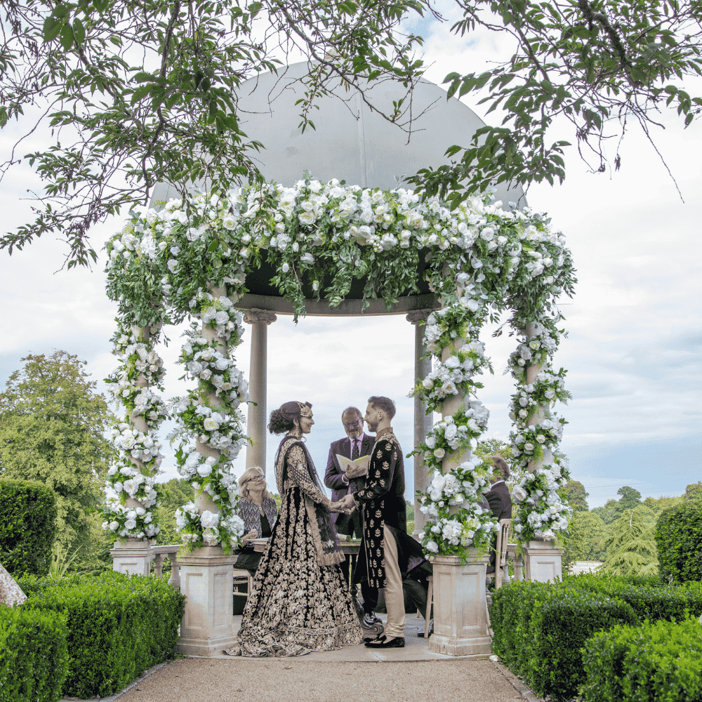A Bride & Groom wearing traditional Asian formal garments celebrate their outdoor civil ceremony at Froyle Park in Surrey.